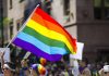 People holding and waving a rainbow flag