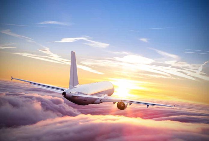 553131187 featured image Airplane flying above clouds during sunset sky