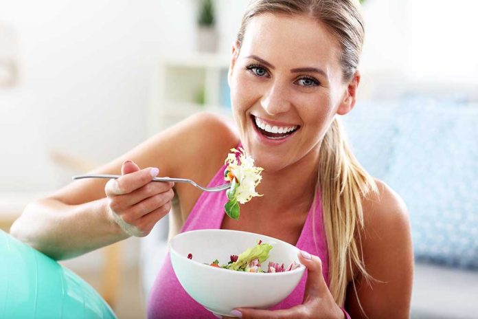 604342055 featured image Woman smiling eating salad with fork indoors