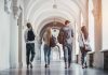 Four students walking in a corridor together