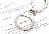 Handcuffs placed on an arrest warrant document