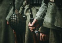 Soldiers in uniform holding rifles and grenades
