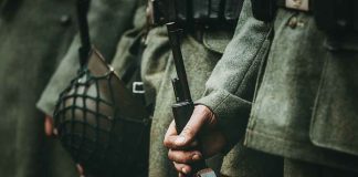 Soldiers in uniform holding rifles and grenades
