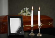 Casket photo frame and two lit candles