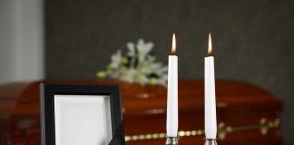 Casket photo frame and two lit candles