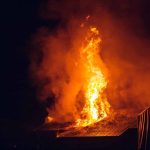 Building engulfed in large flames at night