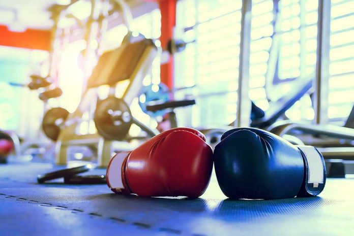 Boxing gloves on gym floor with equipment