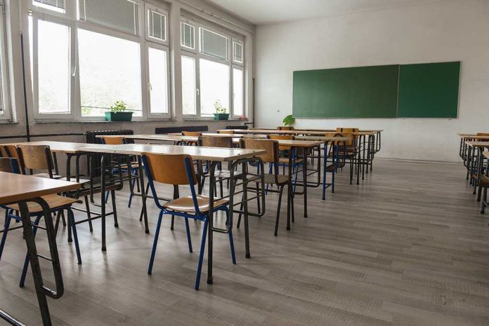 487861393 featured image Empty classroom with desks, chairs, windows, and chalkboard.