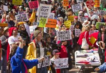 Protesters holding signs about unions and saving the American dream