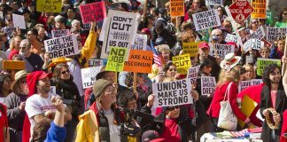 Protesters holding signs about unions and saving the American dream