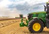 A green tractor in a wheat field