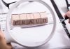 Fraud blocks under magnifying glass on invoices
