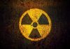 Yellow radiation warning symbol on rusty metal surface