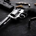 Revolvers and bullets on a dark surface
