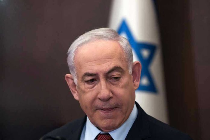2415917203 Man in suit with Israeli flag in background