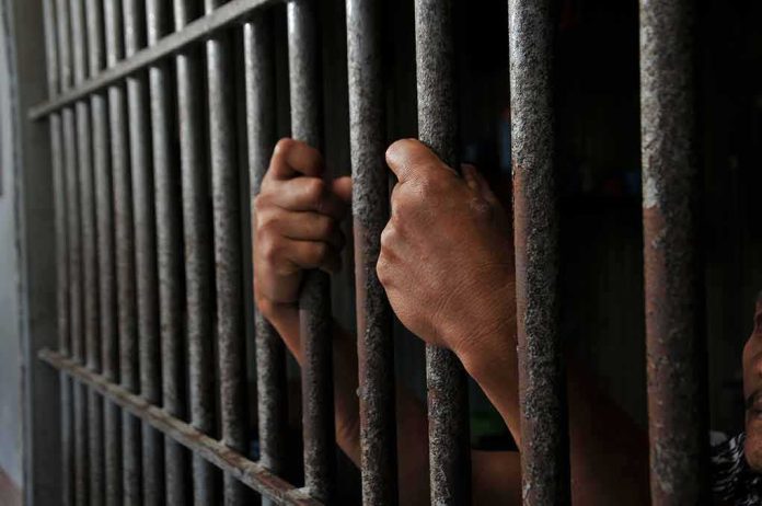 2452368639 featured image Hands gripping jail cell bars