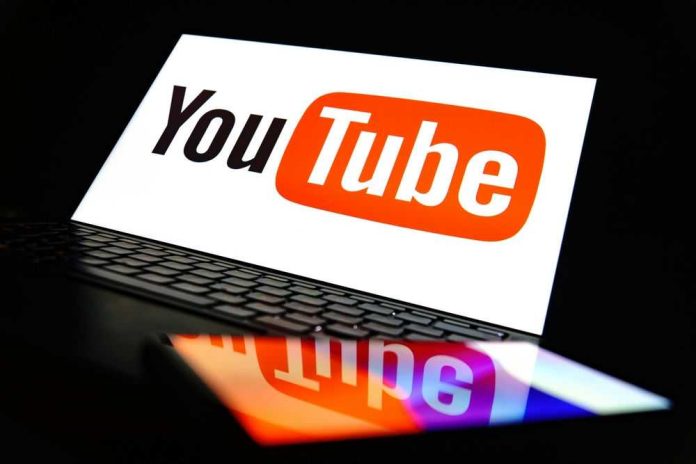 2494901957 YouTube logo on a laptop and smartphone screen