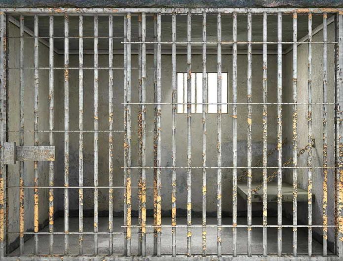 Empty rusty prison cell with a small window