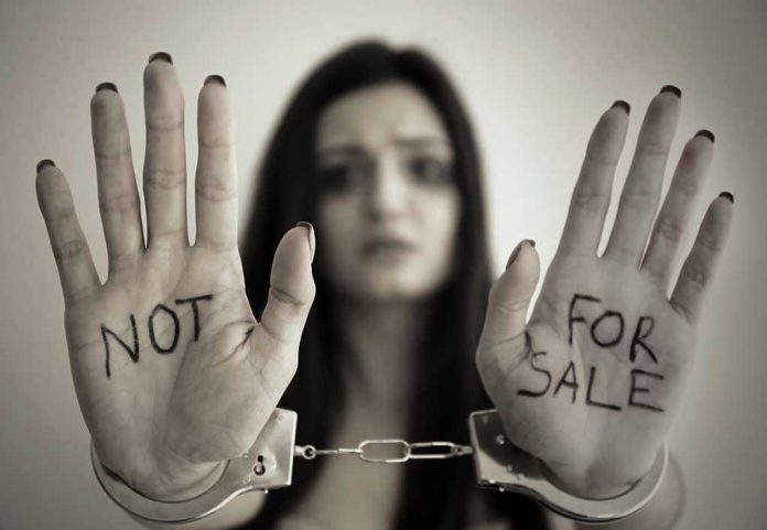 631031339 Handcuffed woman shows "NOT FOR SALE" on her palms.