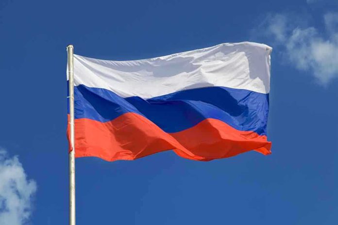 shutterstock_111047630.jpg The flag of Russia waving against a clear blue sky