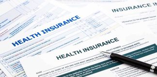 Close up of health insurance application forms with a pen