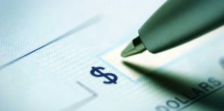 Close up of a pen poised over a check with a dollar sign