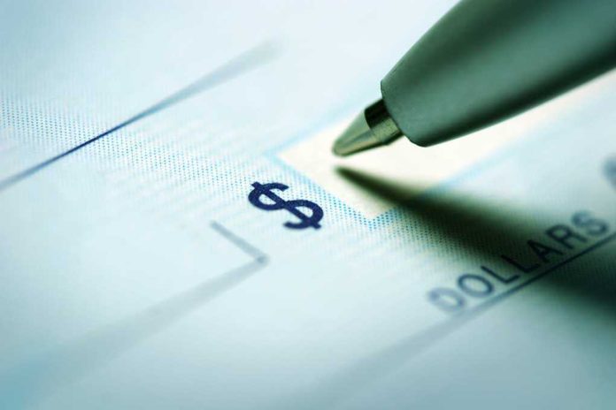 shutterstock_228062581.jpg Close up of a pen poised over a check with a dollar sign