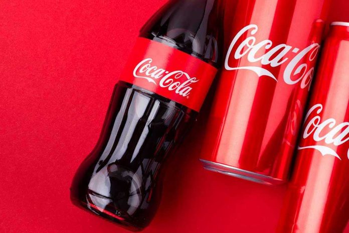 1939159003 Coca-Cola bottles and cans on red background.