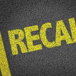 Yellow "RECALL" text on asphalt background.