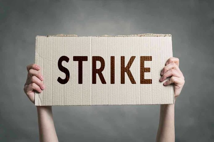 683350906 Two hands holding a cardboard sign saying STRIKE