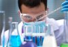 Scientist conducting an experiment with blue liquids in a laboratory
