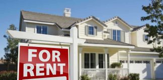 A house with a For Rent sign in the front yard
