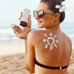 Shocking Beach Towns Where Millionaires Aren’t Required Woman applying sunscreen at the beach.