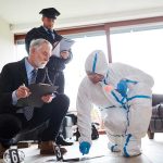 Forensic team examining evidence at a crime scene indoors.