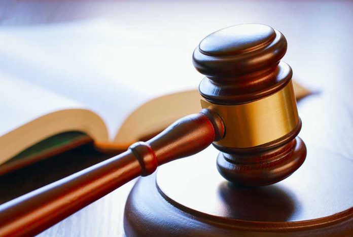 Gavel resting on sounding block beside open book.