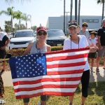 Two women holding an American flag at a community event