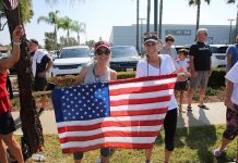Two women holding an American flag at a community event