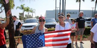 Two women holding an American flag at a community event