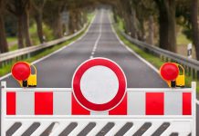 Traffic barrier with a red and white sign blocking a road