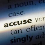 Close-up dictionary definition of accuse underlined.