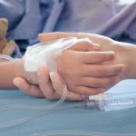HORRIFYING Child Euthanasia Laws SPREAD! Childs hand with IV, held by adult.