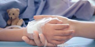 HORRIFYING Child Euthanasia Laws SPREAD! Childs hand with IV, held by adult.