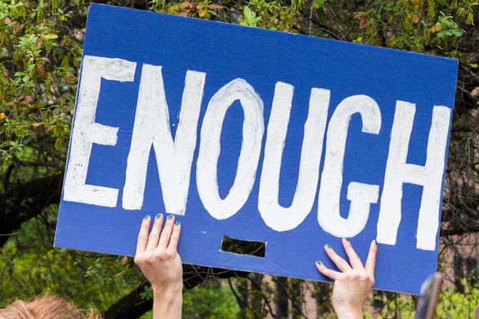 1208630905 Hands holding blue sign saying enough