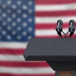 White House Staffer CRUSHES Reporter – Brutal! Podium with microphones in front of American flag.