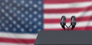 White House Staffer CRUSHES Reporter – Brutal! Podium with microphones in front of American flag.