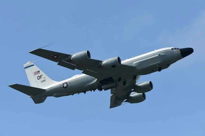 1274771608 Military aircraft flying in clear blue sky.