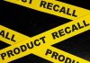 Yellow tape with product recall text on black background.