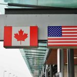 Trump vs. Canada Over FAKE Ad Canadian and American flags displayed at a border crossing
