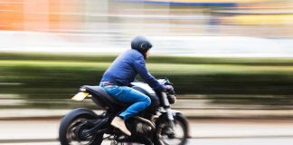 A person riding a motorcycle swiftly through an urban area