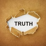 A piece of torn paper revealing the word TRUTH underneath